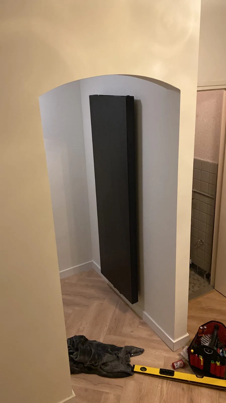 Zwarte verticale designradiator in de hal